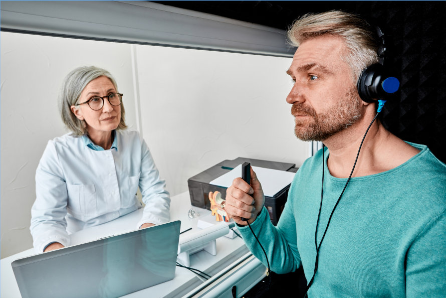 Middle-aged man receiving a hearing test from an audiologist