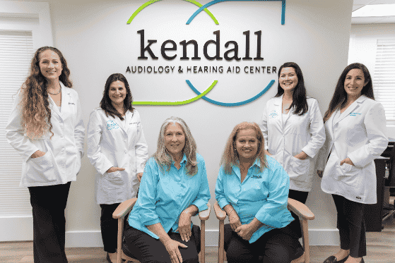 A photo of the team at Kendall Audiology & Hearing Aid Center posing very symmetrically together